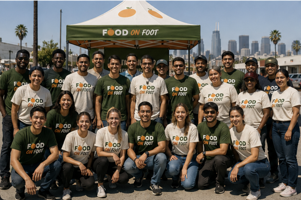 A large group of Food on Foot volunteers gathered in front of the serving tent